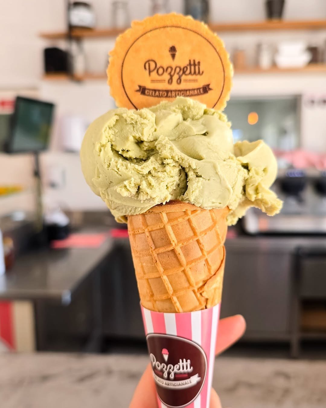 Cone de gelado verde com bolacha Pozzetti, seguro por uma mão